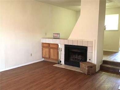 Unfurnished living room with baseboards, dark woo