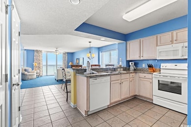 Kitchen featuring kitchen peninsula, a textured ce