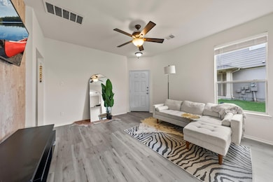 Living area with a ceiling fan and wood finished 