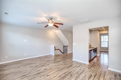 Unfurnished living room featuring ceiling fan, sin
