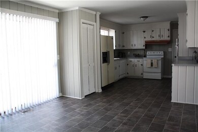 The living room flows directly into the large kitchen/ dining room combination! It's the perfect place for all of the family to gather and is also filled with light from the doors leading out to the backyard!