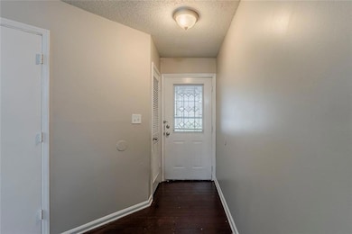 Entryway featuring baseboards, a textured ceiling,