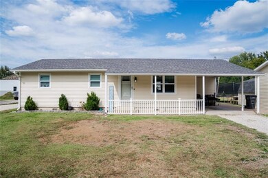 Ranch-style home featuring roof with shingles, a front lawn, and a porch