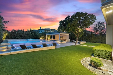 Pool at dusk featuring a lawn, a patio area, an o
