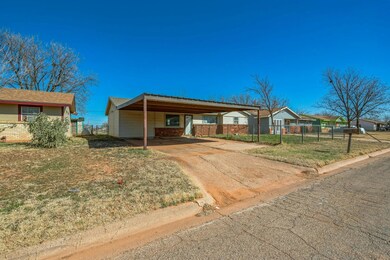 Single story home featuring concrete driveway, fen