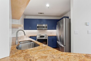 Kitchen with light stone countertops, appliances w
