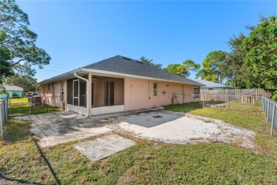 Rear view of house featuring a fenced backyard, a patio area, a sunroom, stucco siding, and roof with shingles