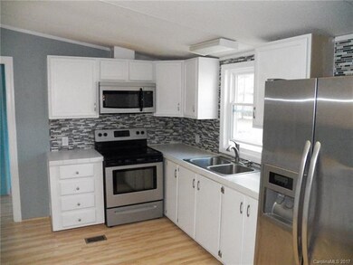 kitchen has lovely tile back splash, stove & refri