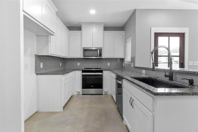 Kitchen with backsplash, dark stone countertops, a