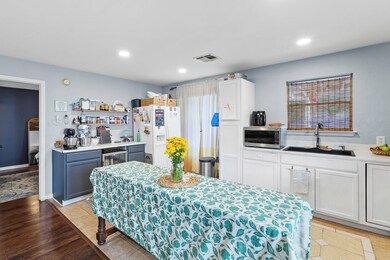 Kitchen with white refrigerator with ice dispenser, stainless steel microwave, recessed lighting, open shelves, and light wood-style floors
