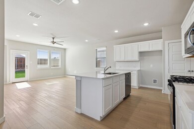 Kitchen featuring gas range, a sink, a ceiling fa