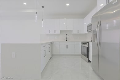 Kitchen with hanging light fixtures, stainless ste