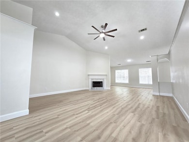 Unfurnished living room featuring ceiling fan, lig