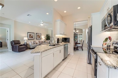 Kitchen featuring appliances with stainless steel finishes, a sink, white cabinetry, a ceiling fan, and light tile patterned flooring