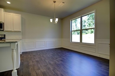 Unfurnished dining area featuring dark wood-type f