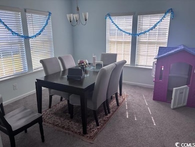 Dining area with carpet floors and a chandelier