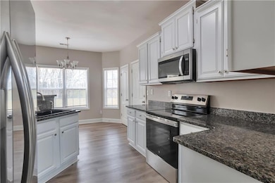Kitchen with a sink, light wood-style floors, appl