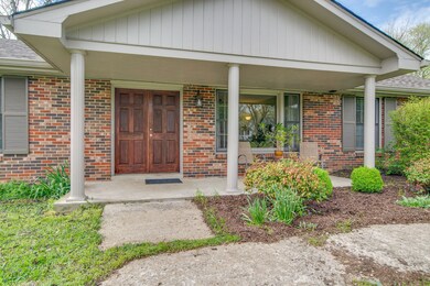 The covered front porch is perfect for a cool drink on a warm day. The rich wooden double entryway welcomes guests into your home.