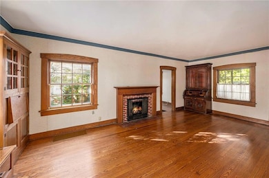 The living room has a gas log fireplace and original window trim.