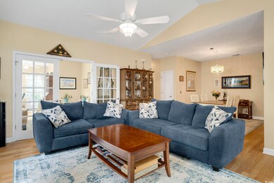 Living room featuring vaulted ceiling, ceiling fan