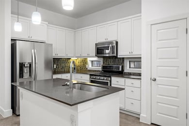 Kitchen featuring dark countertops, tasteful back