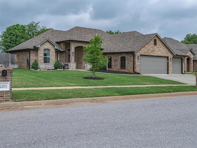 French country home with an attached garage, brick siding, driveway, and a shingled roof