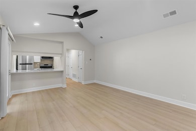 Unfurnished living room with lofted ceiling, a ceiling fan, light wood-type flooring, and recessed lighting