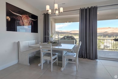 Dining space featuring light tile patterned flooring, a chandelier, and a mountain view