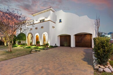 A wide driveway with brick pavers leads to the thr