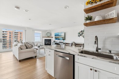 Kitchen featuring dishwasher, white cabinetry, light wood-style flooring, light stone countertops, and crown molding
