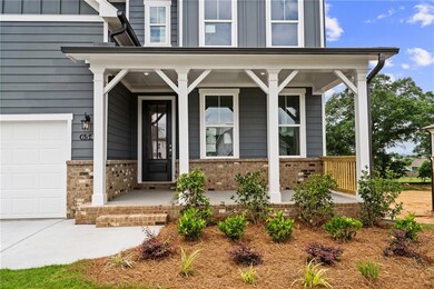 Property entrance featuring a porch, brick siding, and board and batten siding