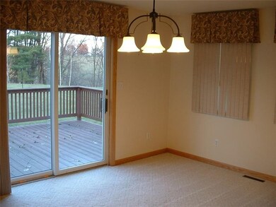 Dining Room leading to  Back Yard Deck and Large Flat Yard surrounded by fields and woods.