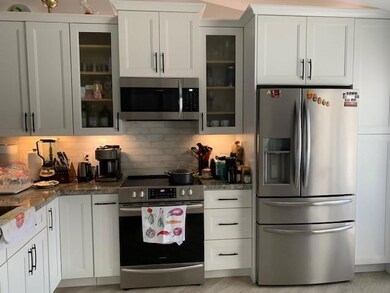 Remodeled kitchen features white shaker cabinets w