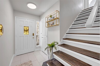 Entryway featuring stairs and light tile patterne