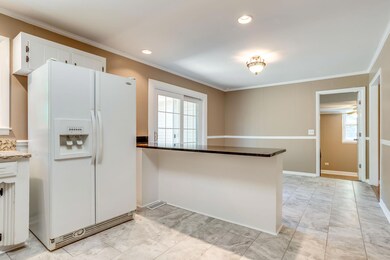 Refrigerator and granite island. French door leads to oversized deck and fabulous backyard