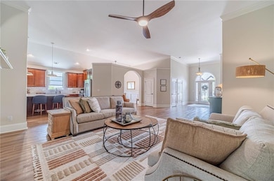 Living room with arched walkways, ceiling fan, bas