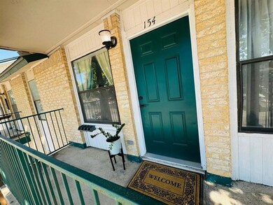 Property entrance with brick siding and a porch