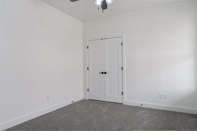 Empty room featuring baseboards, a ceiling fan, an