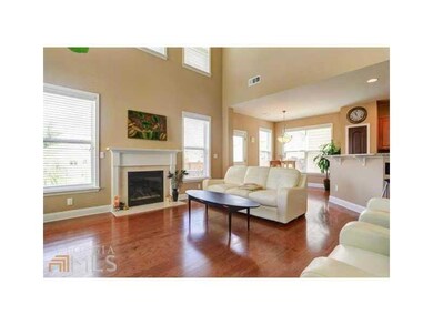 Living room featuring baseboards, dark wood-type flooring, and a fireplace with flush hearth