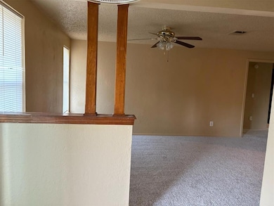 Unfurnished room with carpet floors, ceiling fan, and a textured ceiling is located just off dining room.