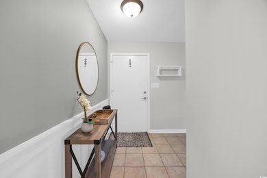 Foyer with light tile patterned floors and a textured ceiling