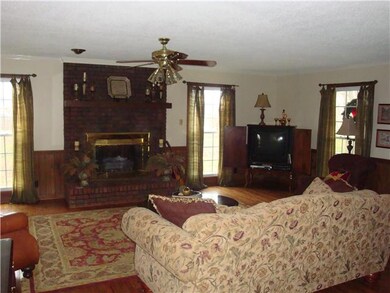 Living Room with Hardwood Flooring and a Fireplace that has Gas Logs installed. 