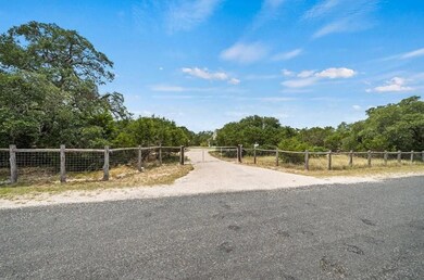 View of road featuring a wooded view and a gated 