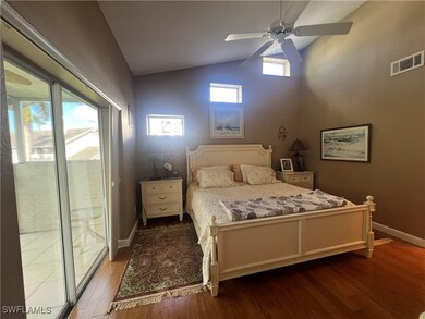 Bedroom with access to outside, wood finished floors, a ceiling fan, and high vaulted ceiling