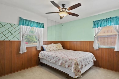Bedroom with a wainscoted wall, wooden walls, a ce