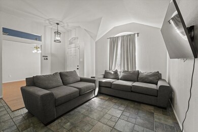 Living room featuring ceiling fan, dark tile patte