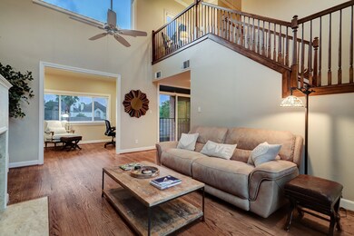 Towering ceilings and a thoughtful flowing floorplan boast real wood floors of Oak, 4 inch base boards, stylish trim and more! This view of the spacious Family Room shows some of the blue sky views enjoyed in every room and a peak into the coveted bonus room, perfect for Home Office/Study. Note the high end double pane windows w/ automatic shades, fireplace and mantle, open stair case w/ bonus landing, recessed lighting and more!