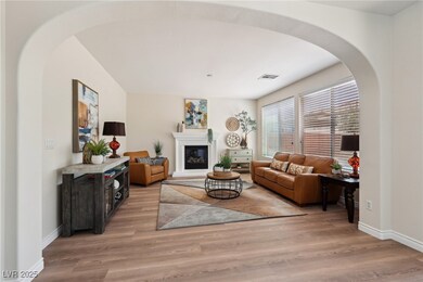Living area featuring arched walkways, light wood