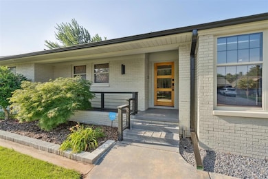 Property entrance featuring brick siding and a porch