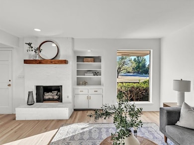 Living room featuring a fireplace, light wood-style flooring, and recessed lighting